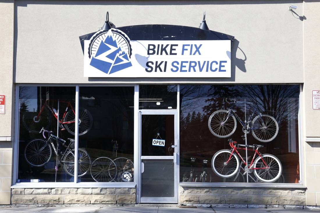 Storefront with the Bike Fix Ski Service sign and bikes hanging in the windows